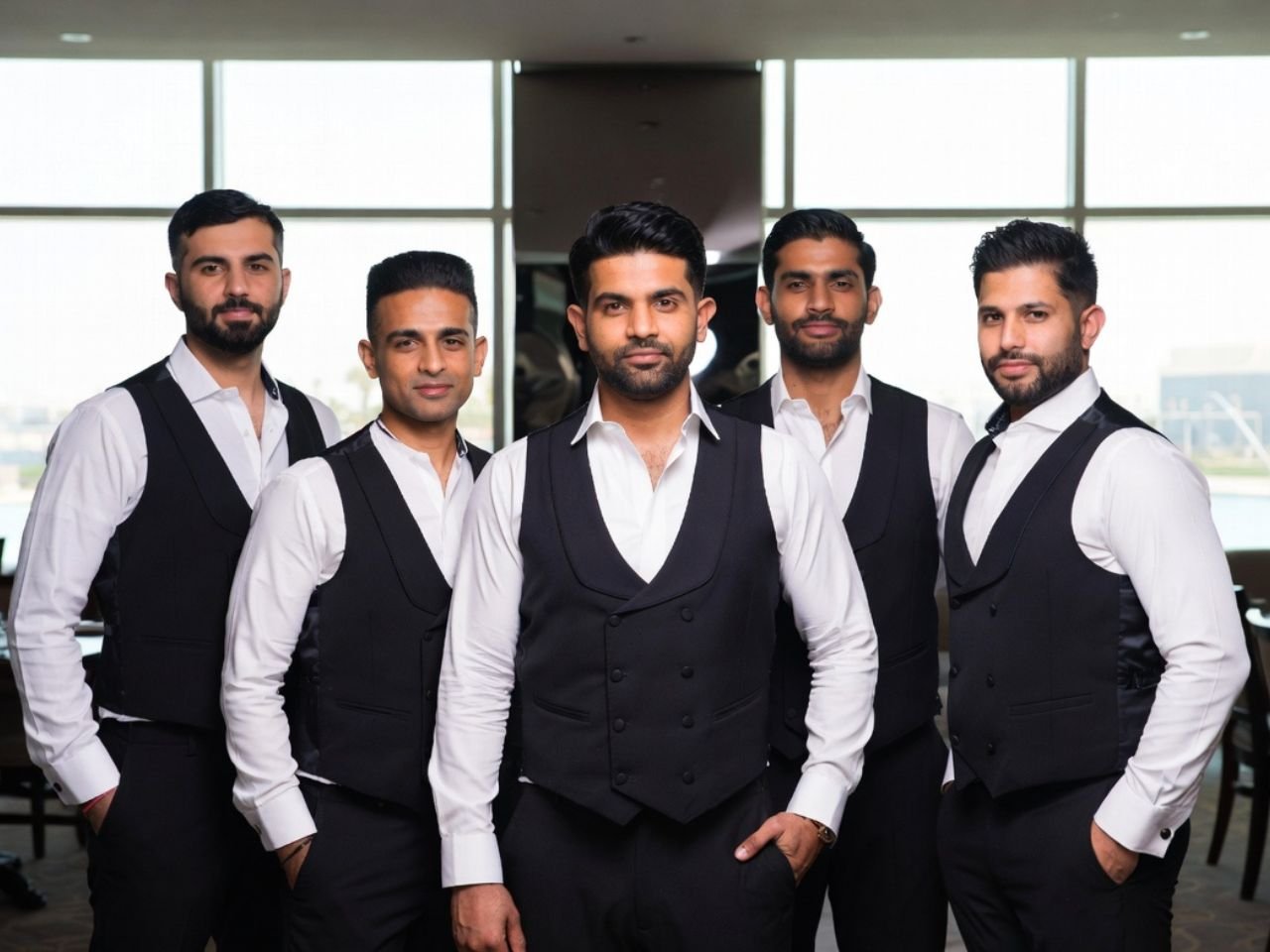A group of well-groomed, professional male F&B waiters and banquet servers standing in formal black vests and white shirts, supplied by MSQ, a trusted F&B manpower supplier in Qatar.